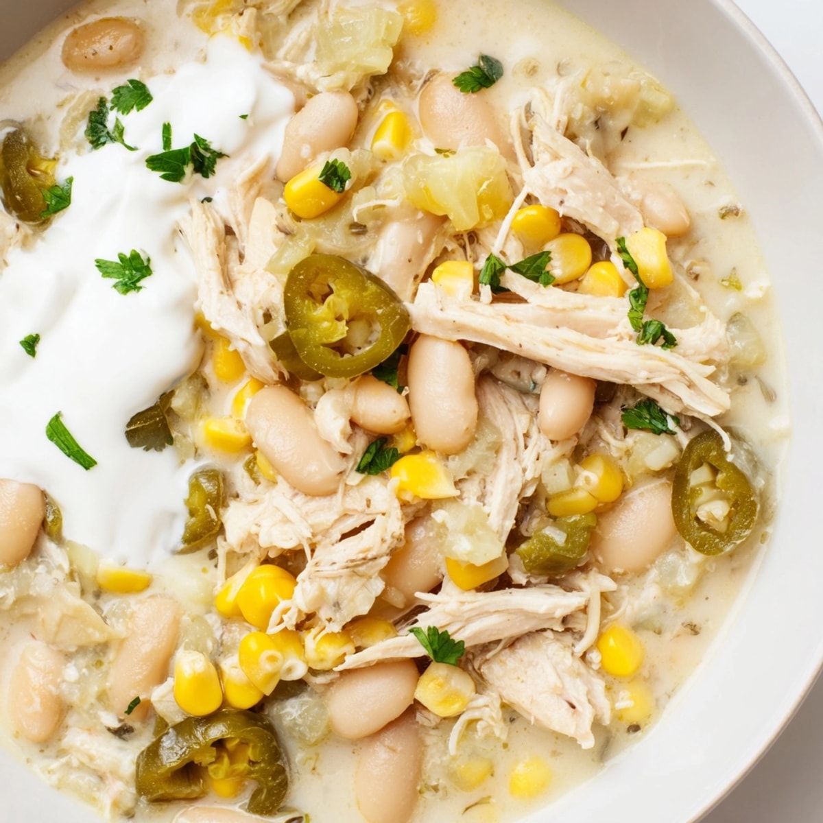 Hearty One-Pot Pickle-Fix White Chicken Chili featuring creamy ranch dollops and diced pickles.