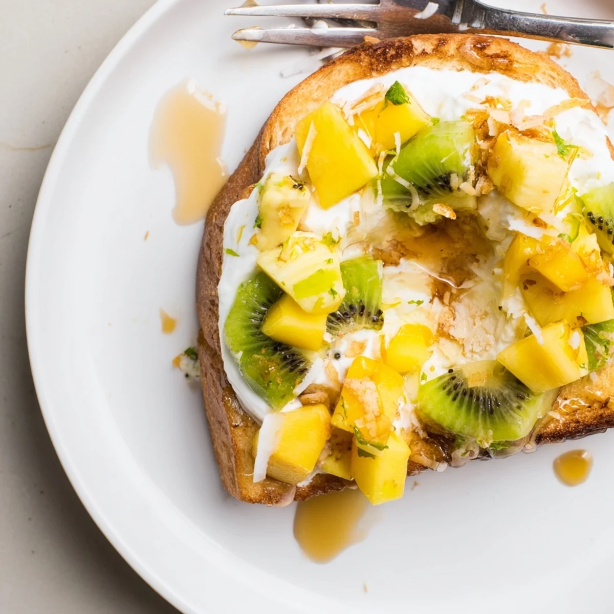 Creamy yogurt-custard toast topped with tropical fruits for a delightful brunch.  