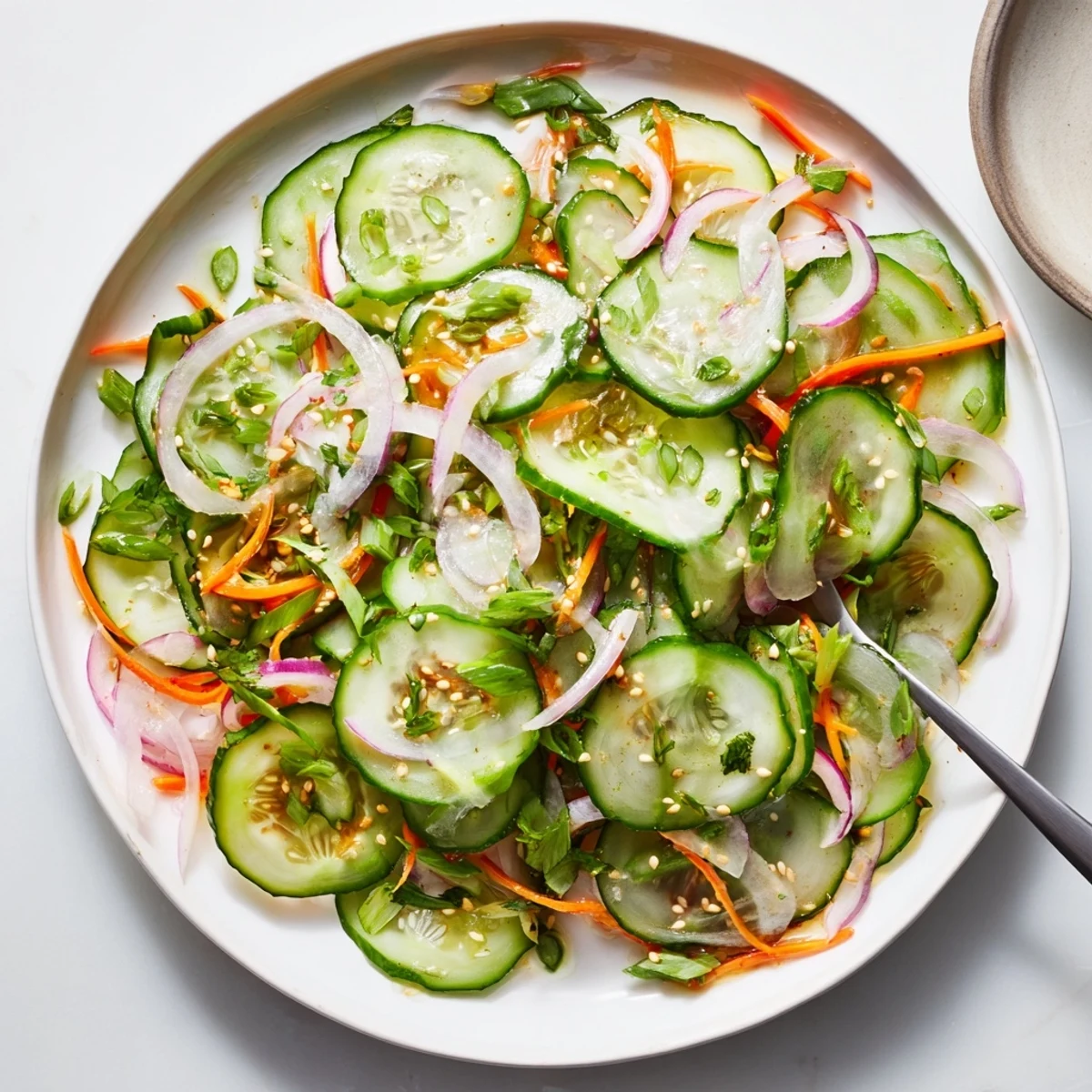 Refreshing cucumber salad remix with vibrant vegetables and tangy sesame dressing.  