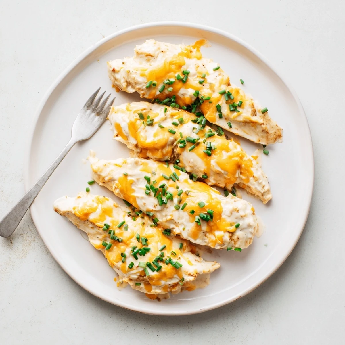 Comforting Cheddar Ranch Chicken Bake garnished with fresh chives and melted cheese.  