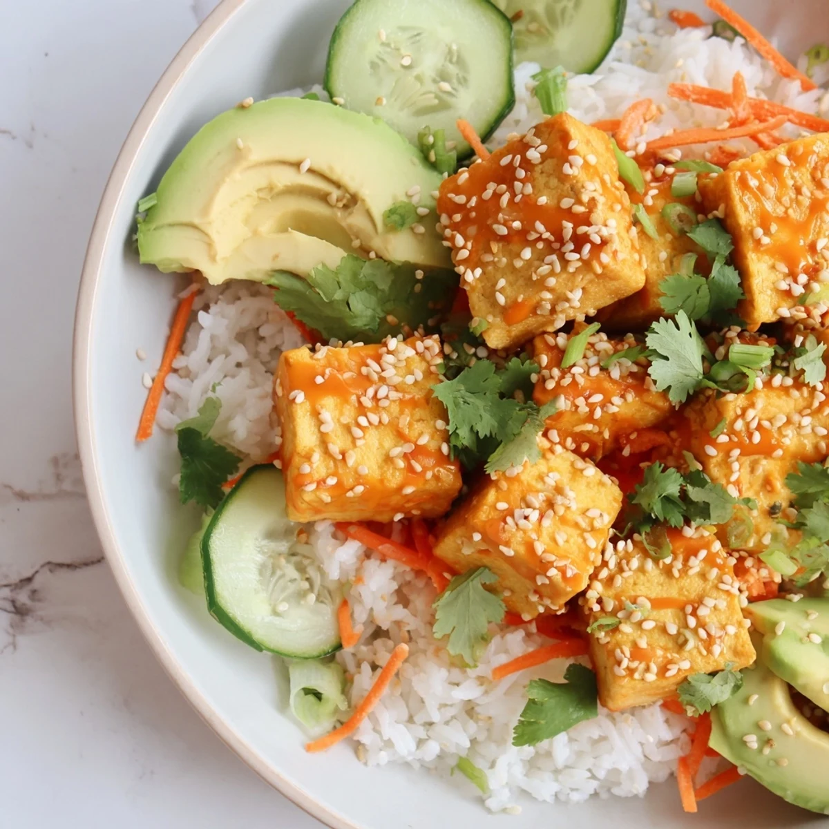 Chili-Mayo Baked Tofu Bowls: Crispy tofu cubes coated in spicy sauce, served over fluffy rice, a vibrant meal.