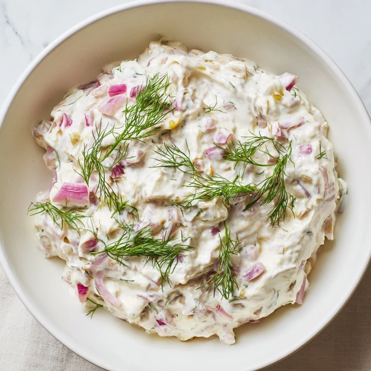 A scoop of sweet and sour pickle relish dip, showcasing its creamy texture, ready to be served on a burger.