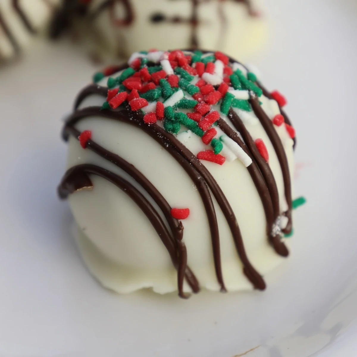 Rich and creamy Simplified Christmas Oreo Truffles, ready to devour, look amazing next to colorful sprinkles.