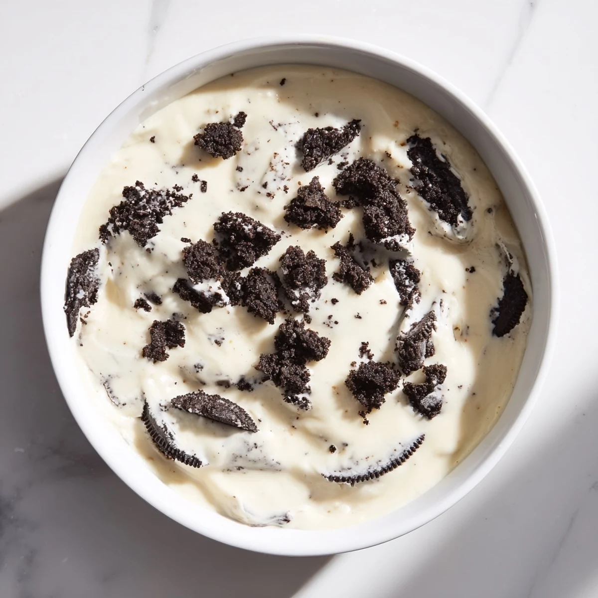This decadent photo shows Vanilla Pudding with crushed Oreos, ready to eat, with a creamy, textured consistency.