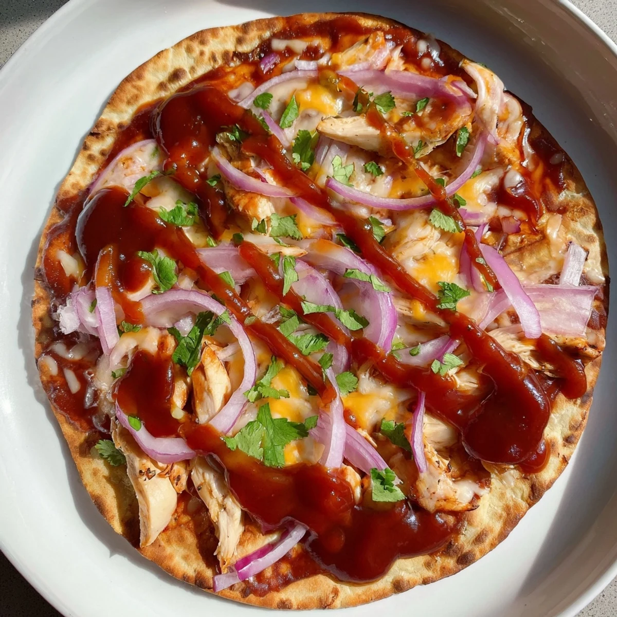 This image shows a BBQ Chicken Flatbread with melty cheese, inviting you to enjoy the savory flavors.
