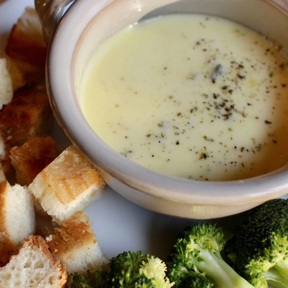 Warm, bubbling Swiss cheese fondue with crusty bread cubes ready for dipping and enjoying.