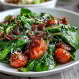 Fresh dandelion greens salad with lemon vinaigrette and Parmesan, vibrant and zesty with cherry tomatoes and pine nuts.
