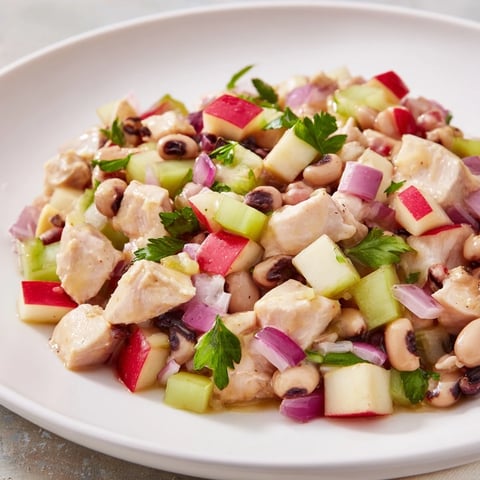 A colorful Chicken and Apple New Years Luck Salad, served with toasted pecans, ready for a festive meal.