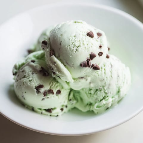 A scoop of refreshing, homemade Mint Chocolate Chip Ice Cream, perfect for a summer dessert.