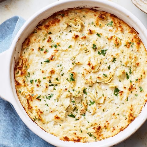 Creamy, cheesy Baked Artichoke Dip, studded with artichoke hearts, is a party appetizer favorite.