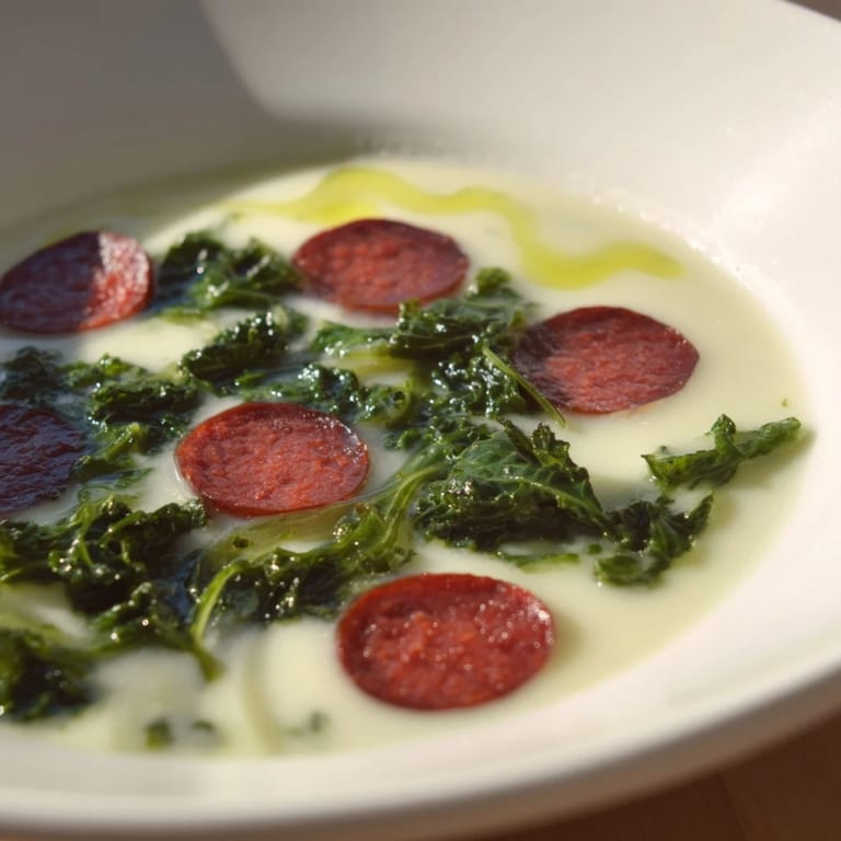 A vibrant overhead shot of hearty Portuguese Caldo Verde, a rustic soup perfect for a chilly evening.