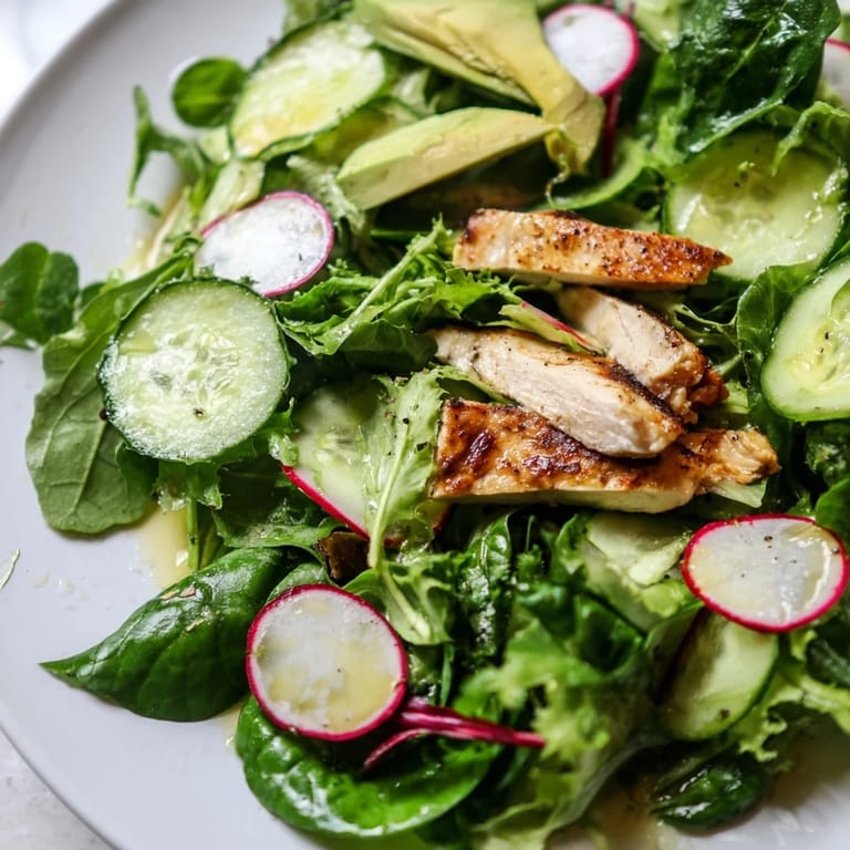 Freshly prepared Spring Detox Chicken Salad is garnished with lemon wedges and tossed with vibrant veggies and vinaigrette.